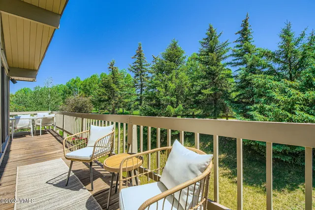 a view of a green field with trees in the background