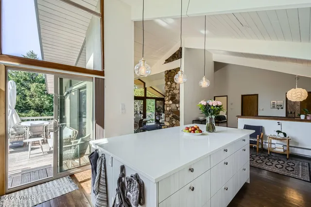a living room with furniture large window and wooden floor