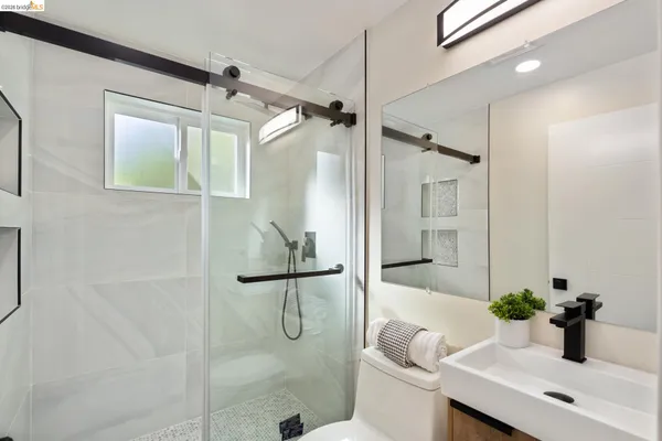 a bathroom with a granite countertop sink a toilet and shower