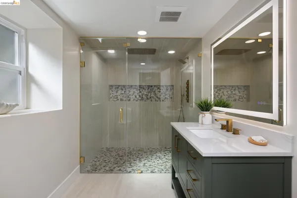 a bathroom with a granite countertop sink a mirror and shower