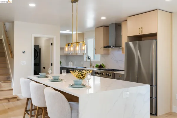 a kitchen with stainless steel appliances a sink a stove a refrigerator and cabinets