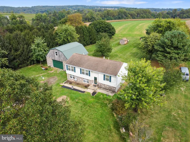 an aerial view of a house with a garden and lake view