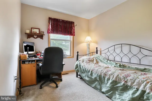 a bedroom with a bed chair and a fireplace