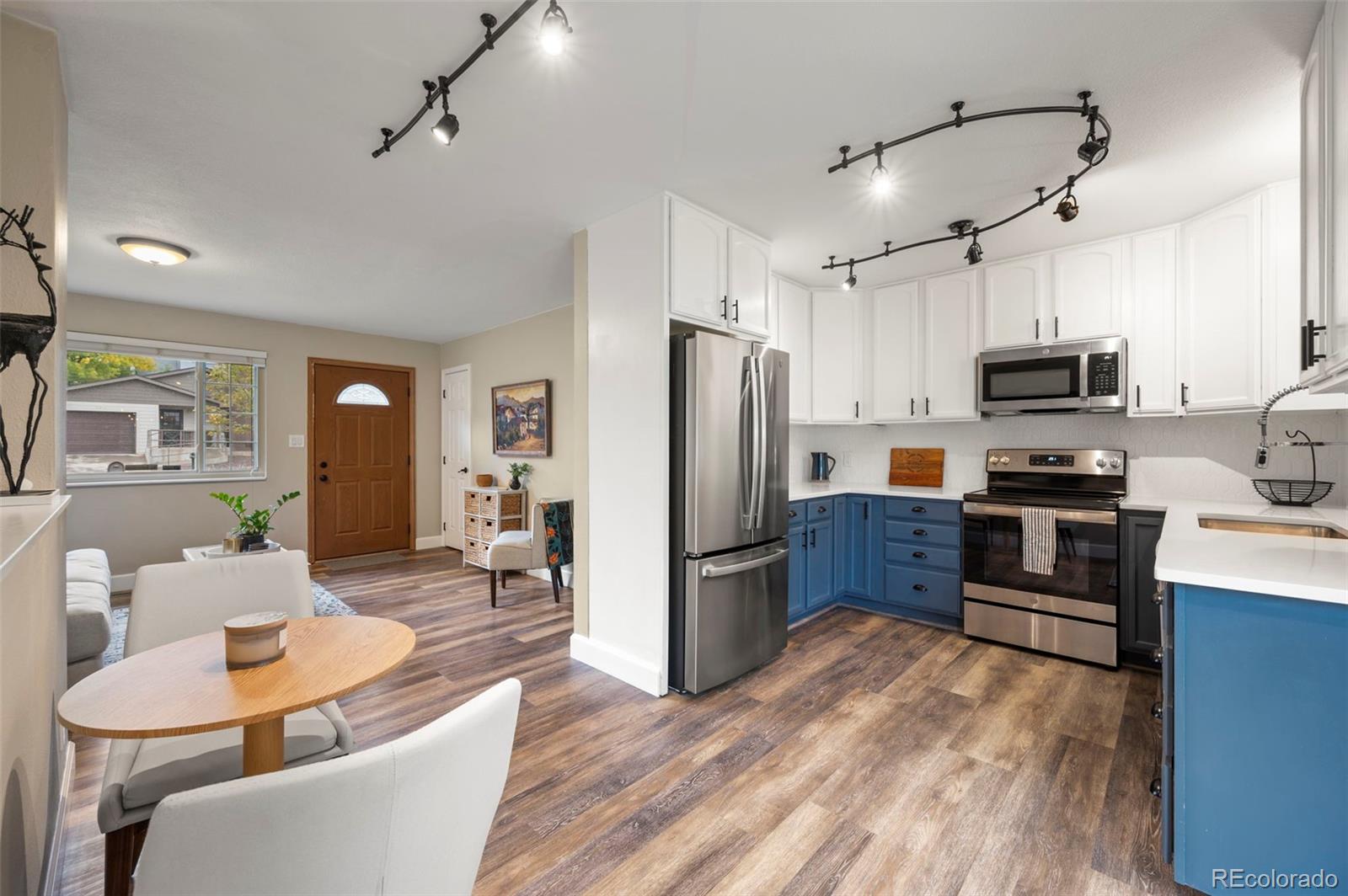 186 Quaker Street Golden, CO 80401 - Photo 11 of 50 a kitchen with stainless steel appliances granite countertop a refrigerator a stove top oven a sink dishwasher a dining table and chairs with wooden floor