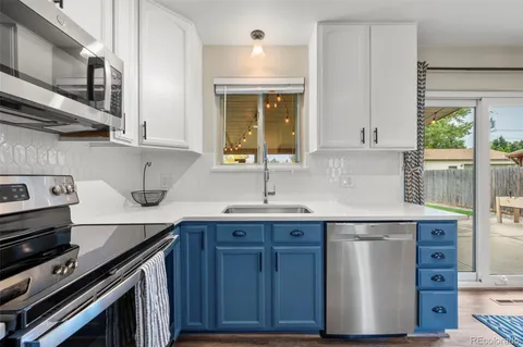 a kitchen with stainless steel appliances granite countertop a sink stove and cabinets