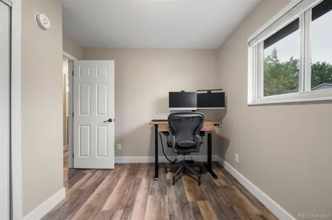 a view of a workspace with furniture and a window
