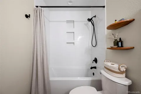 a bathroom with a shower a toilet and a shower
