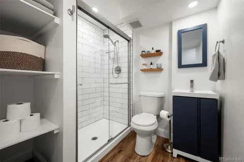 a bathroom with a toilet sink vanity and shower