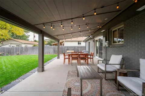 a view of a patio with table and chairs potted plants with wooden floor and fence
