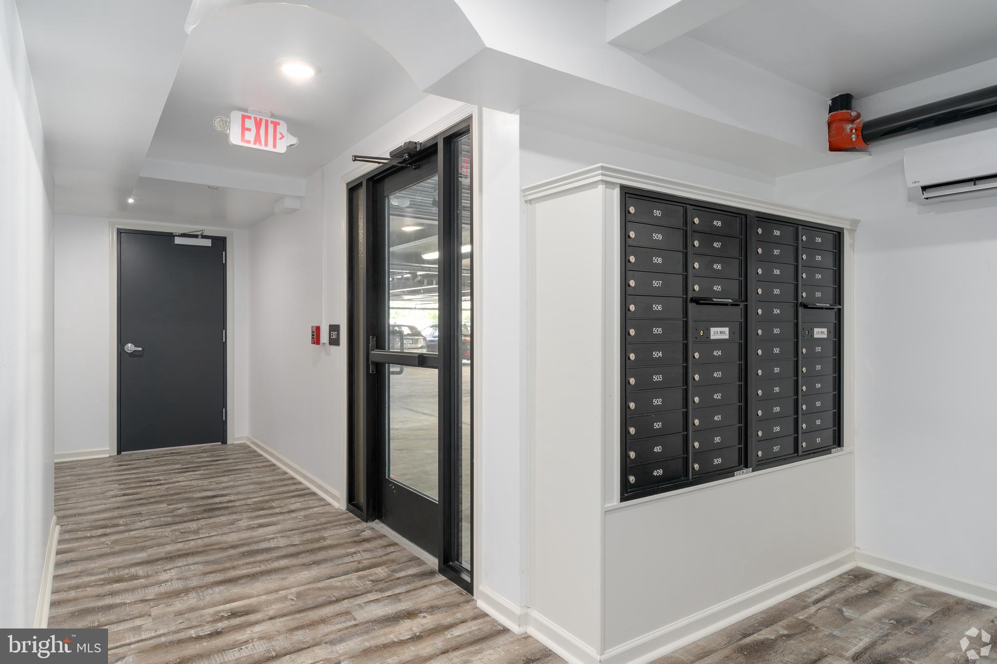 6618 Ridge Avenue, Unit 401 Philadelphia, PA 19128 - Photo 5 of 6 a view of a hallway with wooden floor and cabinet