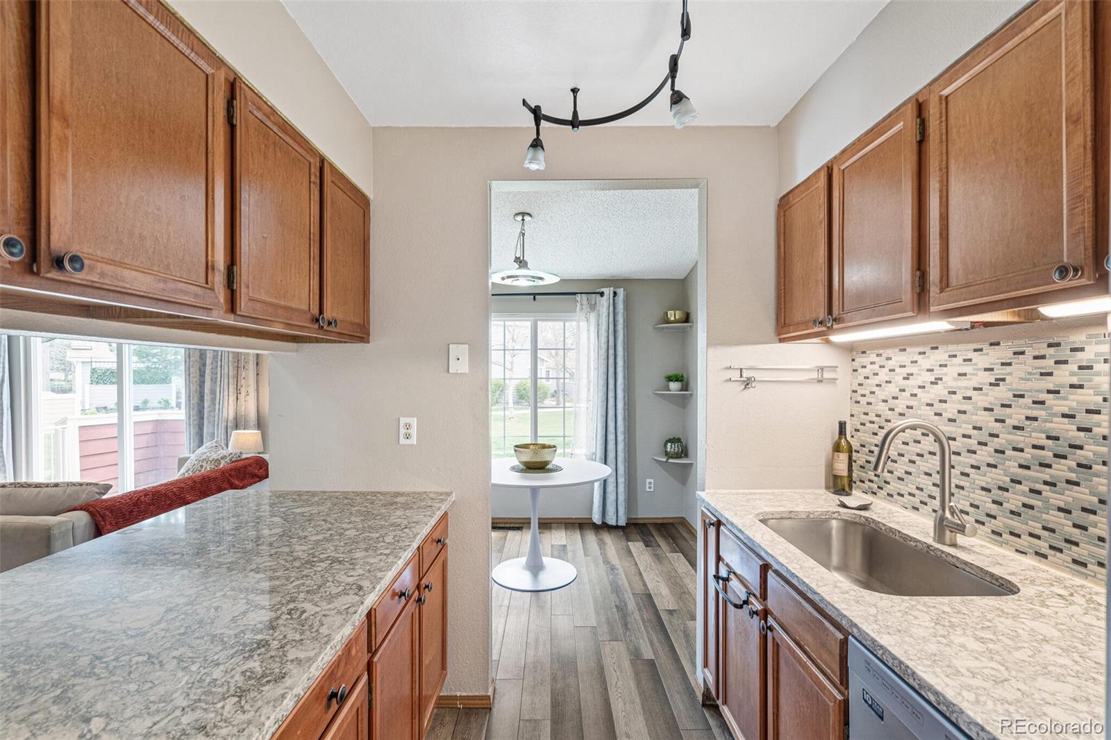 8424 Everett Way, Unit A Arvada, CO 80005 - Photo 11 of 25 a kitchen with granite countertop a sink a counter space cabinets and stainless steel appliances