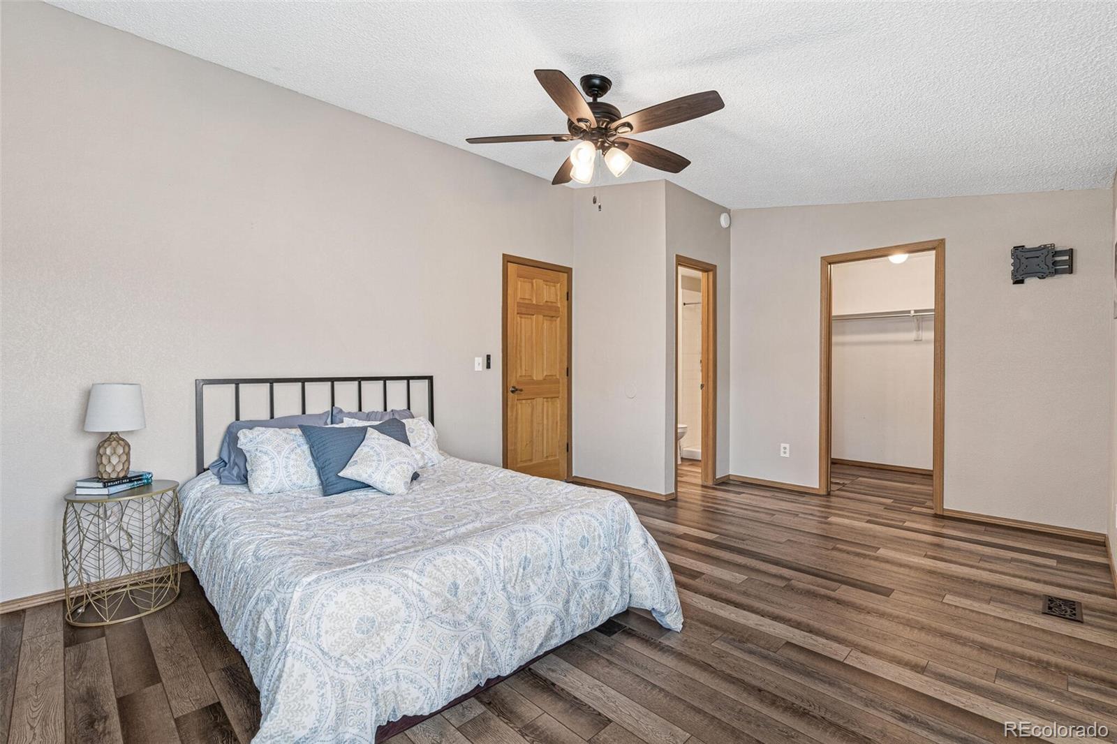 8424 Everett Way, Unit A Arvada, CO 80005 - Photo 14 of 25 a bedroom with a large bed and a chandelier
