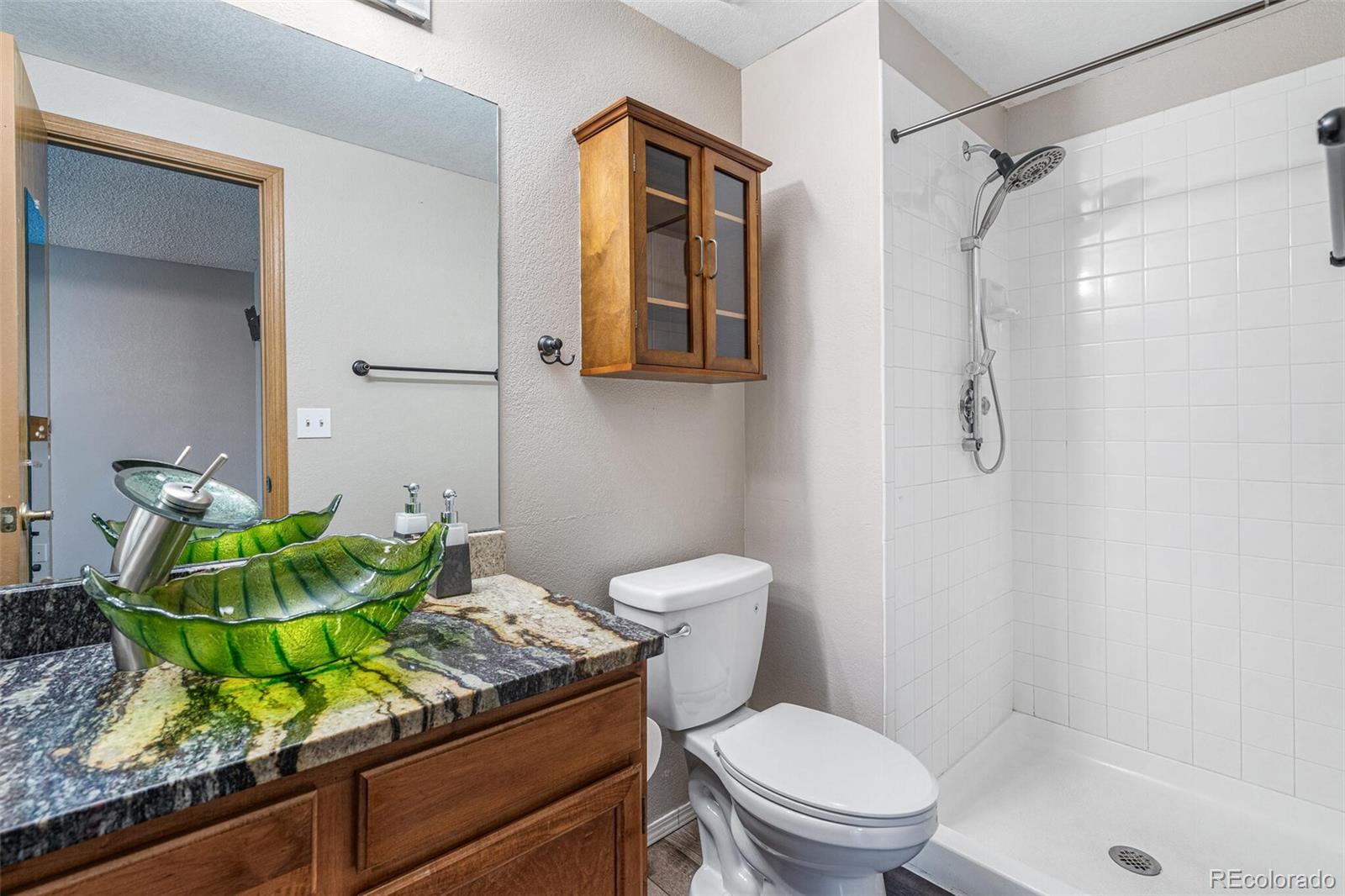 8424 Everett Way, Unit A Arvada, CO 80005 - Photo 15 of 25 a bathroom with a granite countertop sink a toilet and shower