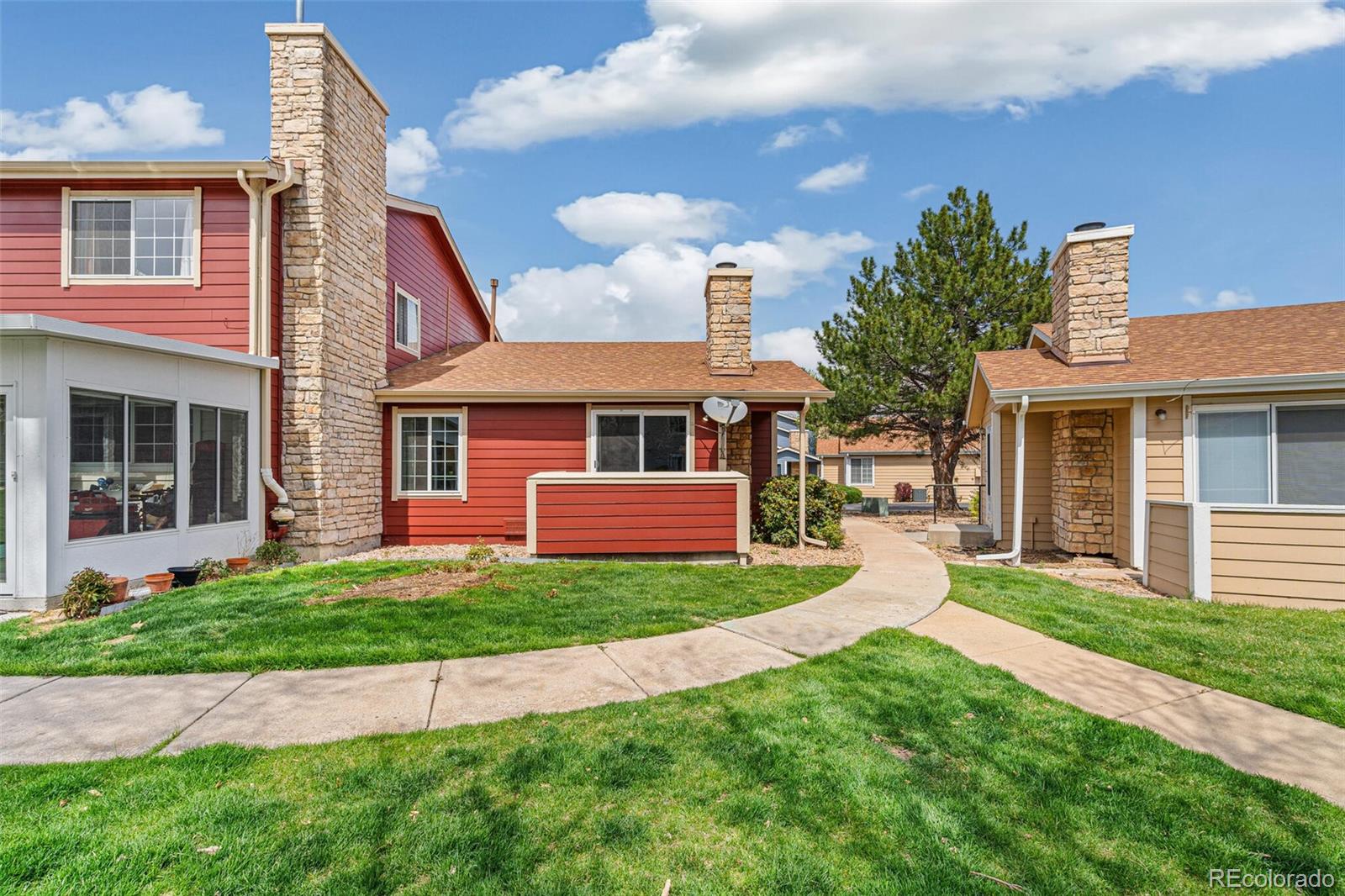 8424 Everett Way, Unit A Arvada, CO 80005 - Photo 19 of 25 a front view of a house with a yard and garage