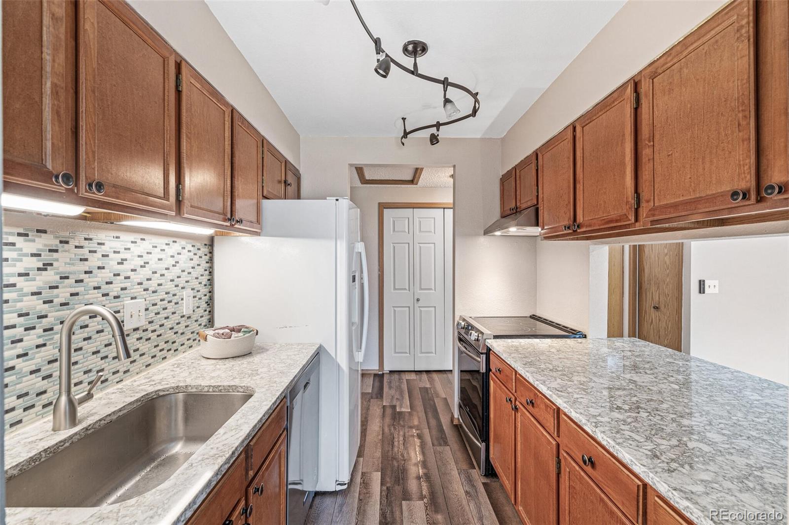 8424 Everett Way, Unit A Arvada, CO 80005 - Photo 9 of 25 a kitchen with stainless steel appliances granite countertop a sink stove and refrigerator