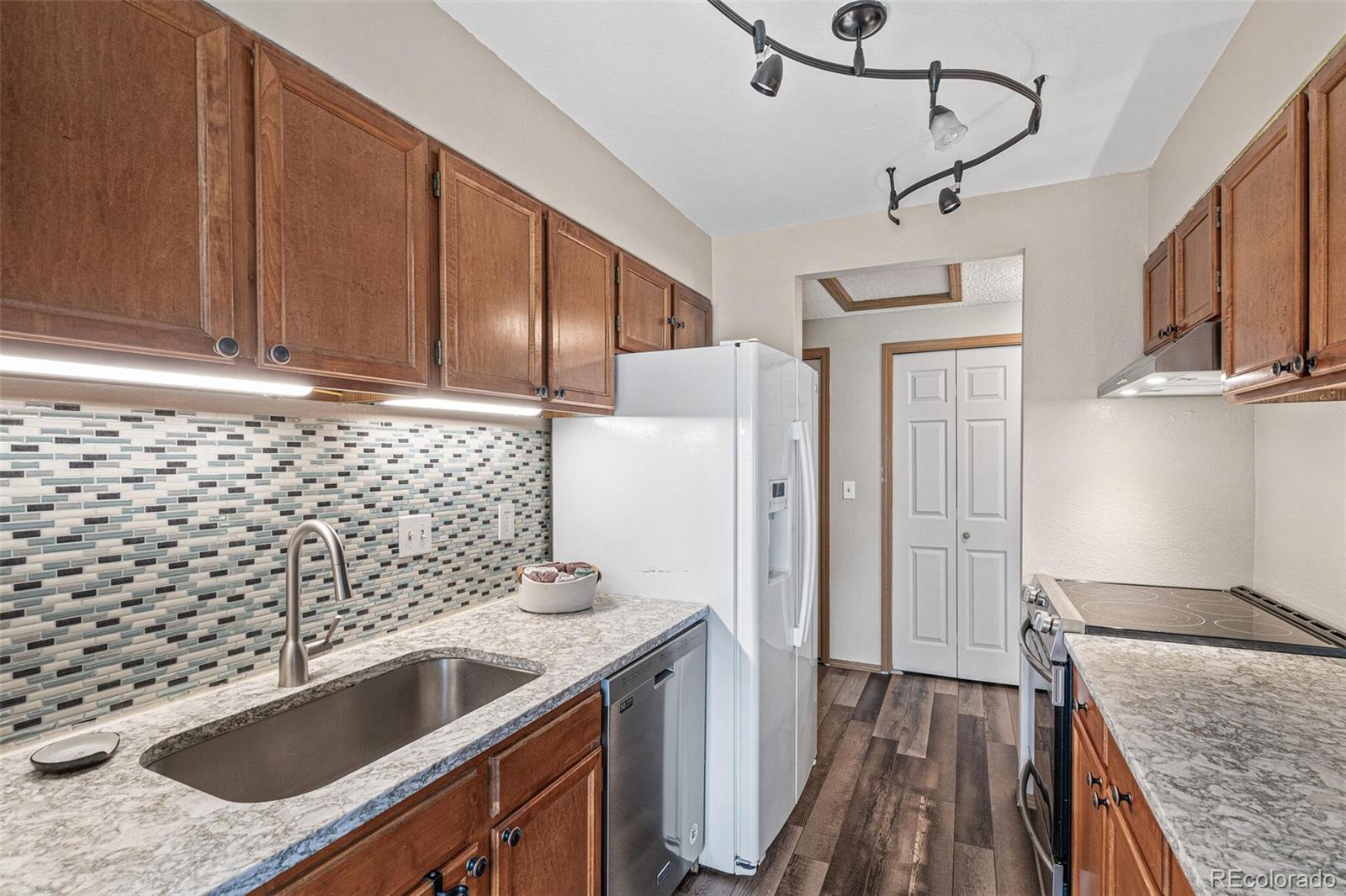 8424 Everett Way, Unit A Arvada, CO 80005 - Photo 10 of 25 a kitchen with stainless steel appliances granite countertop a sink stove and refrigerator