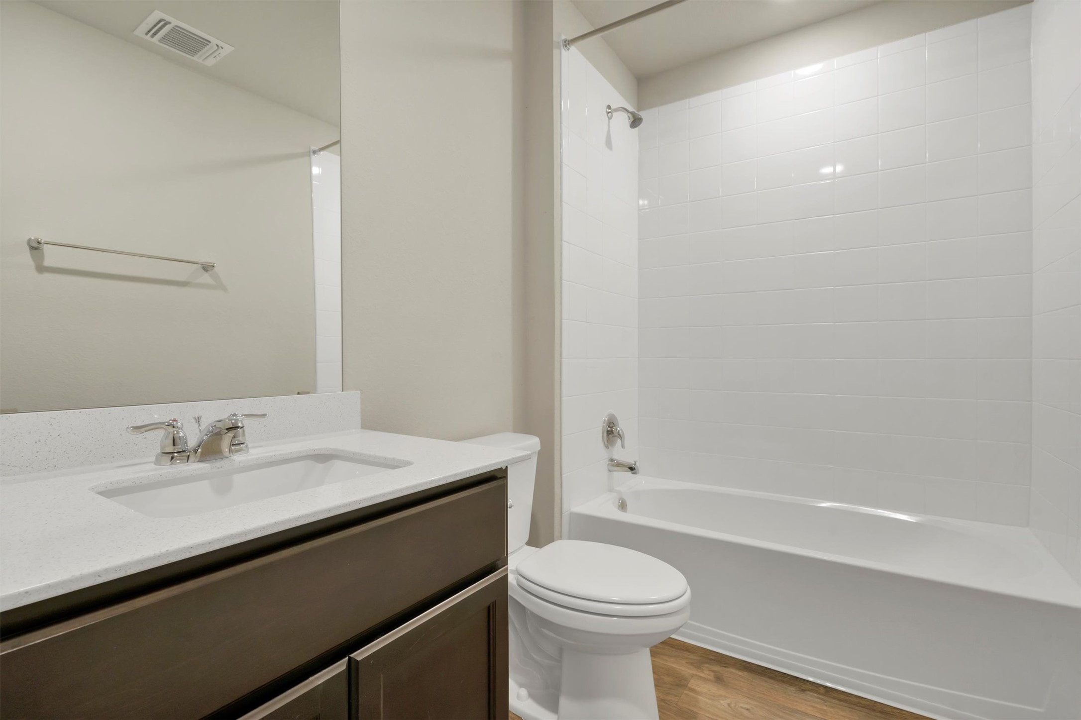 2909 Tweedy Trail Pflugerville, TX 78660 - Photo 11 of 27 A well-appointed bathroom featuring a contemporary vanity, pristine white tile shower, and wood-look flooring.