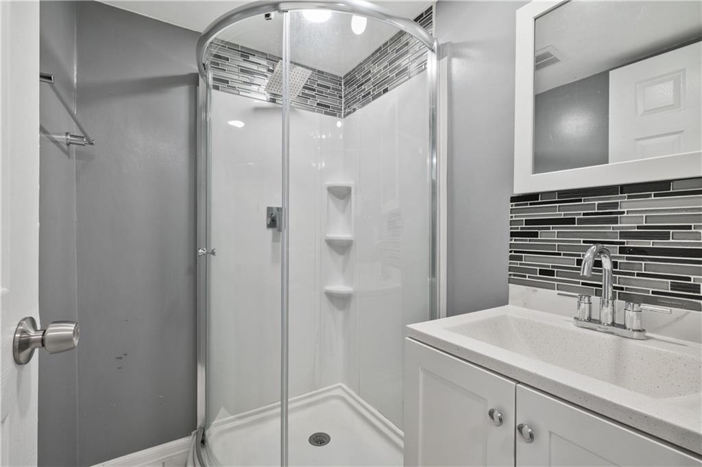 2203 Open Meadow Circle Bridgeville, PA 15017 - Photo 21 of 29 a bathroom with a sink a mirror and shower