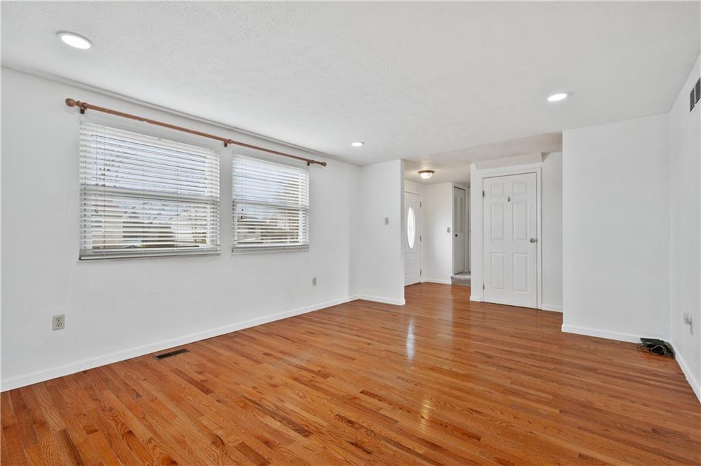 2203 Open Meadow Circle Bridgeville, PA 15017 - Photo 5 of 29 a view of an empty room with wooden floor and a window