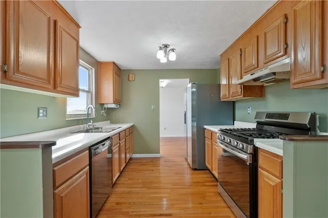 a kitchen with stainless steel appliances granite countertop a stove a sink dishwasher and a refrigerator