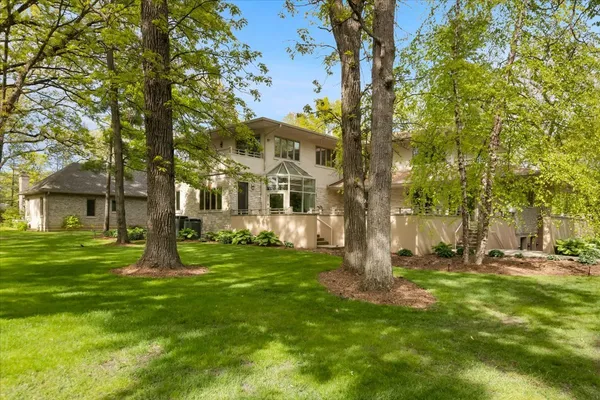a view of a house with a yard and large tree