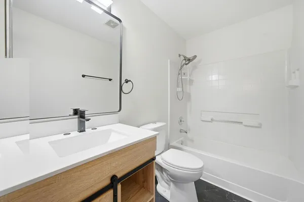 a bathroom with a sink a toilet and shower