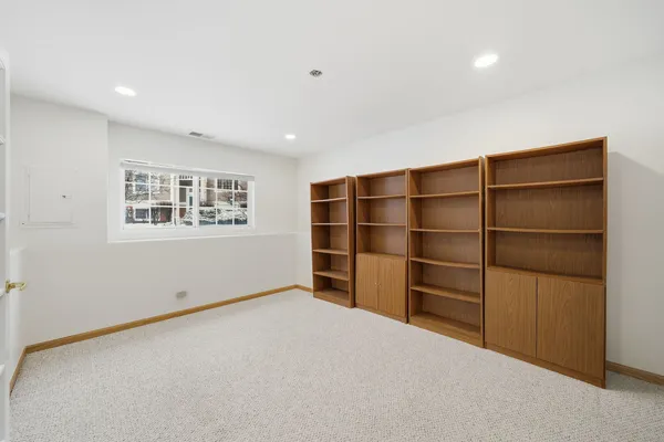 a view of an empty room with a cabinet and a window