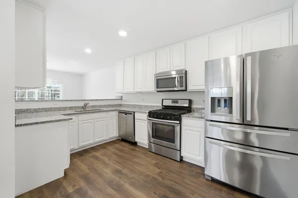 a kitchen with stainless steel appliances granite countertop a refrigerator stove a sink and microwave