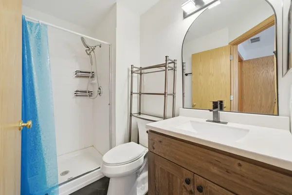 a bathroom with a sink a toilet and shower