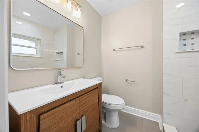 a bathroom with a sink a toilet and a mirror