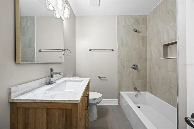 a bathroom with a granite countertop sink a toilet and shower