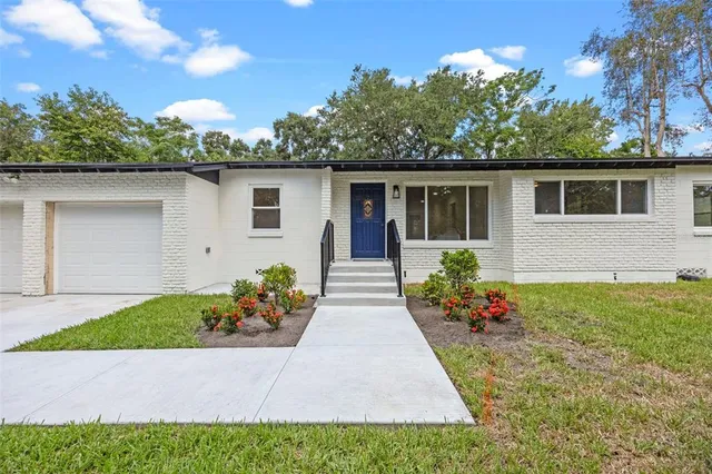 a view of a house with a yard and potted plants