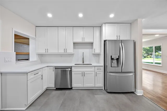 a kitchen with a refrigerator sink and cabinets