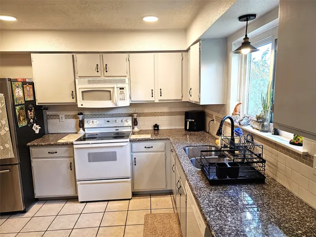 a kitchen with a stove a sink and a microwave