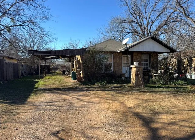 a view of a house with backyard and trees