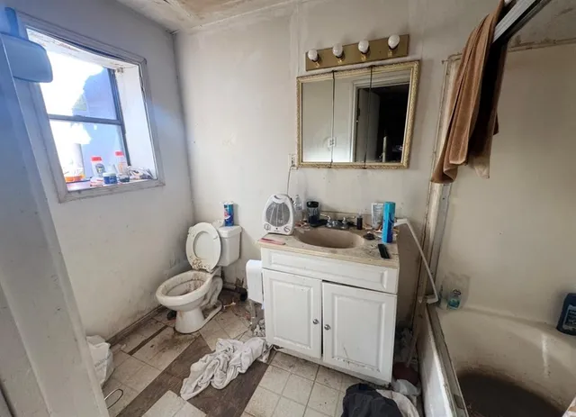 a bathroom with a toilet sink and mirror