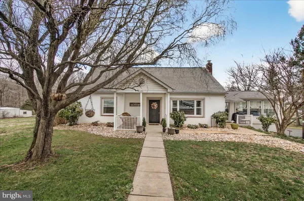 a front view of a house with garden and trees