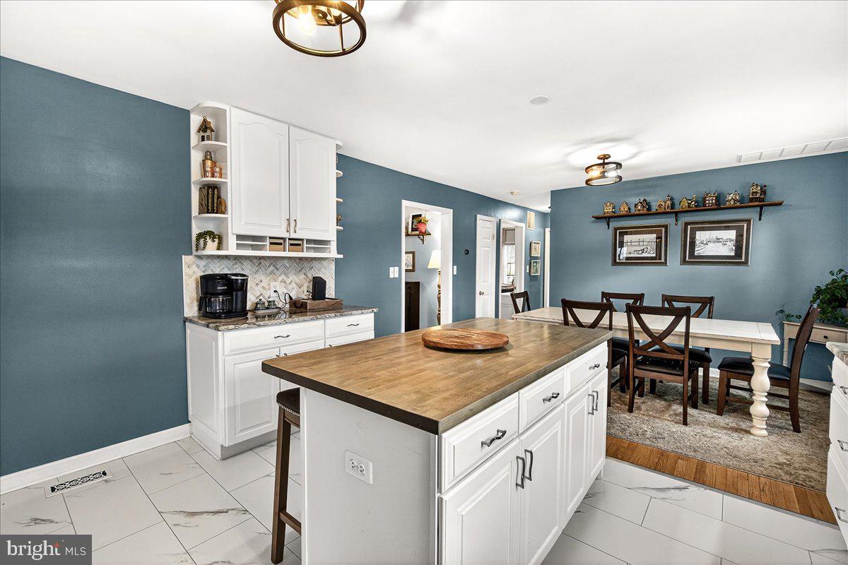 7201 Mountain Church Road Middletown, MD 21769 - Photo 11 of 37 a kitchen with stainless steel appliances granite countertop a stove top oven a sink a dining table and chairs