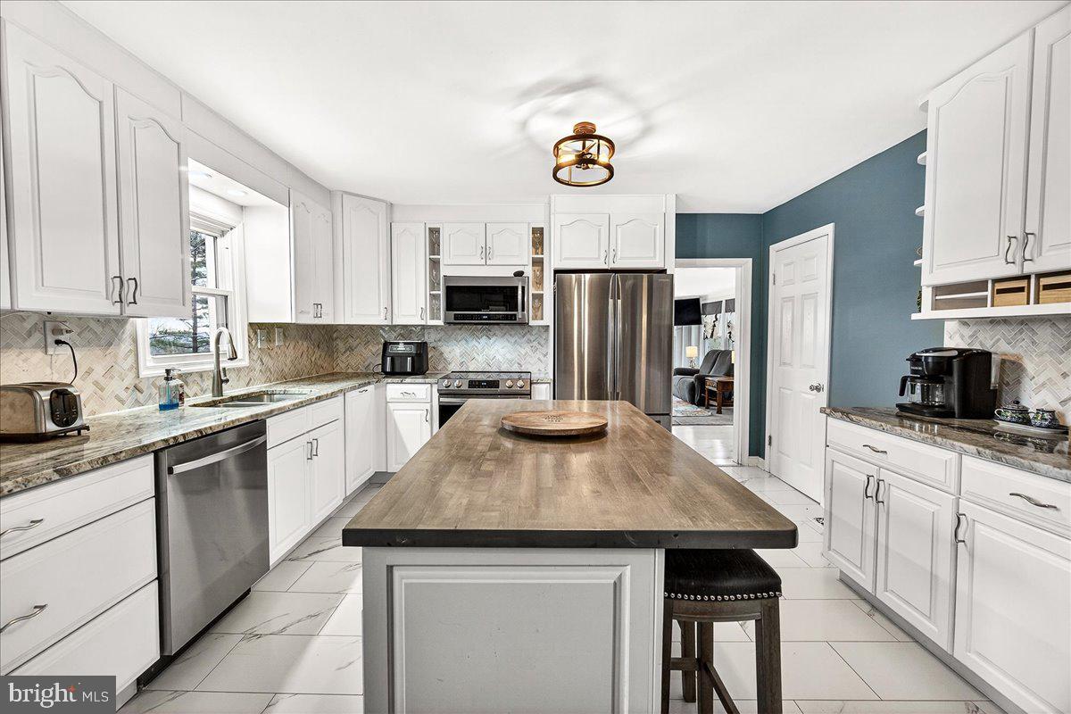 7201 Mountain Church Road Middletown, MD 21769 - Photo 12 of 37 a kitchen with kitchen island granite countertop stainless steel appliances cabinets a sink and a center island