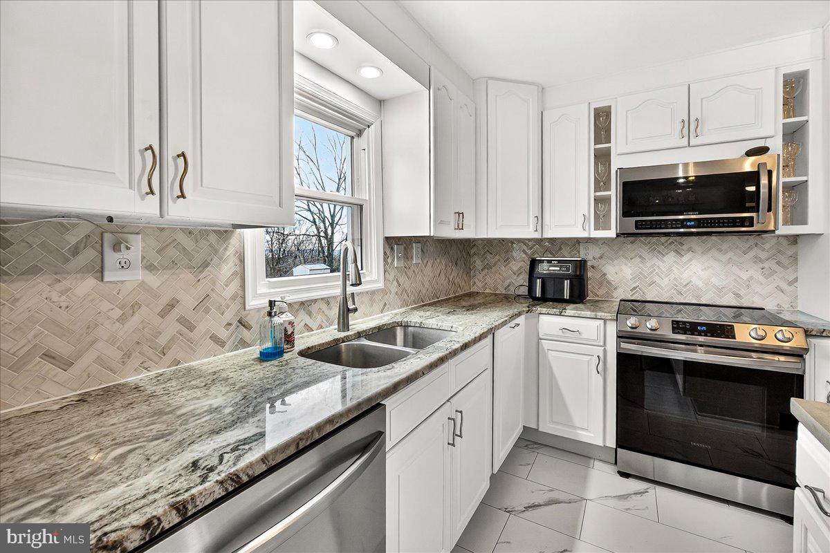 7201 Mountain Church Road Middletown, MD 21769 - Photo 14 of 37 a kitchen with granite countertop a sink a stove and microwave