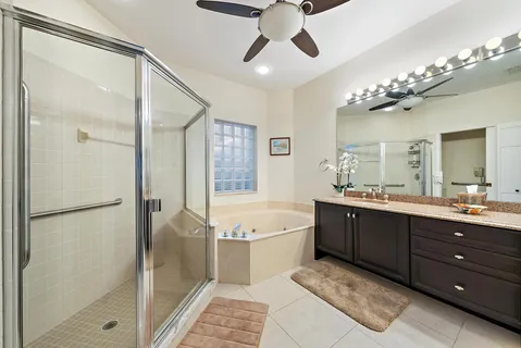 a spacious bathroom with a tub sink shower and mirror