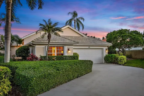 a front view of a house with a garden and yard