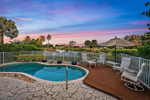 a view of a swimming pool with a lounge chair and a yard