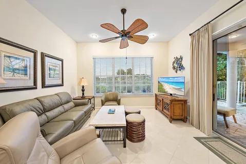 a living room with furniture a ceiling fan and a window