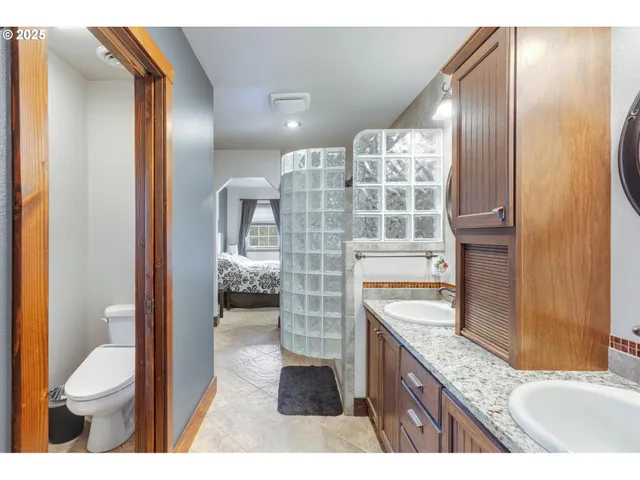 a bathroom with a granite countertop sink toilet and shower