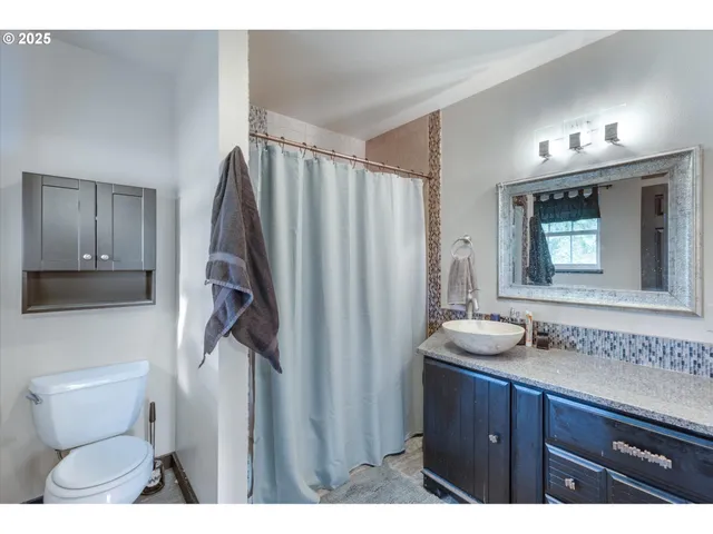 a bathroom with a toilet a sink and mirror