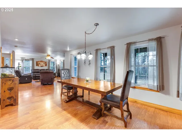 a living room with furniture a dining table and a large window