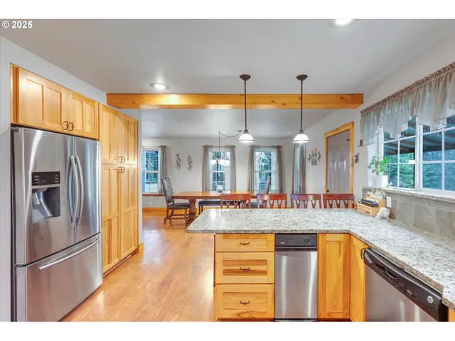 a kitchen with sink refrigerator and large window