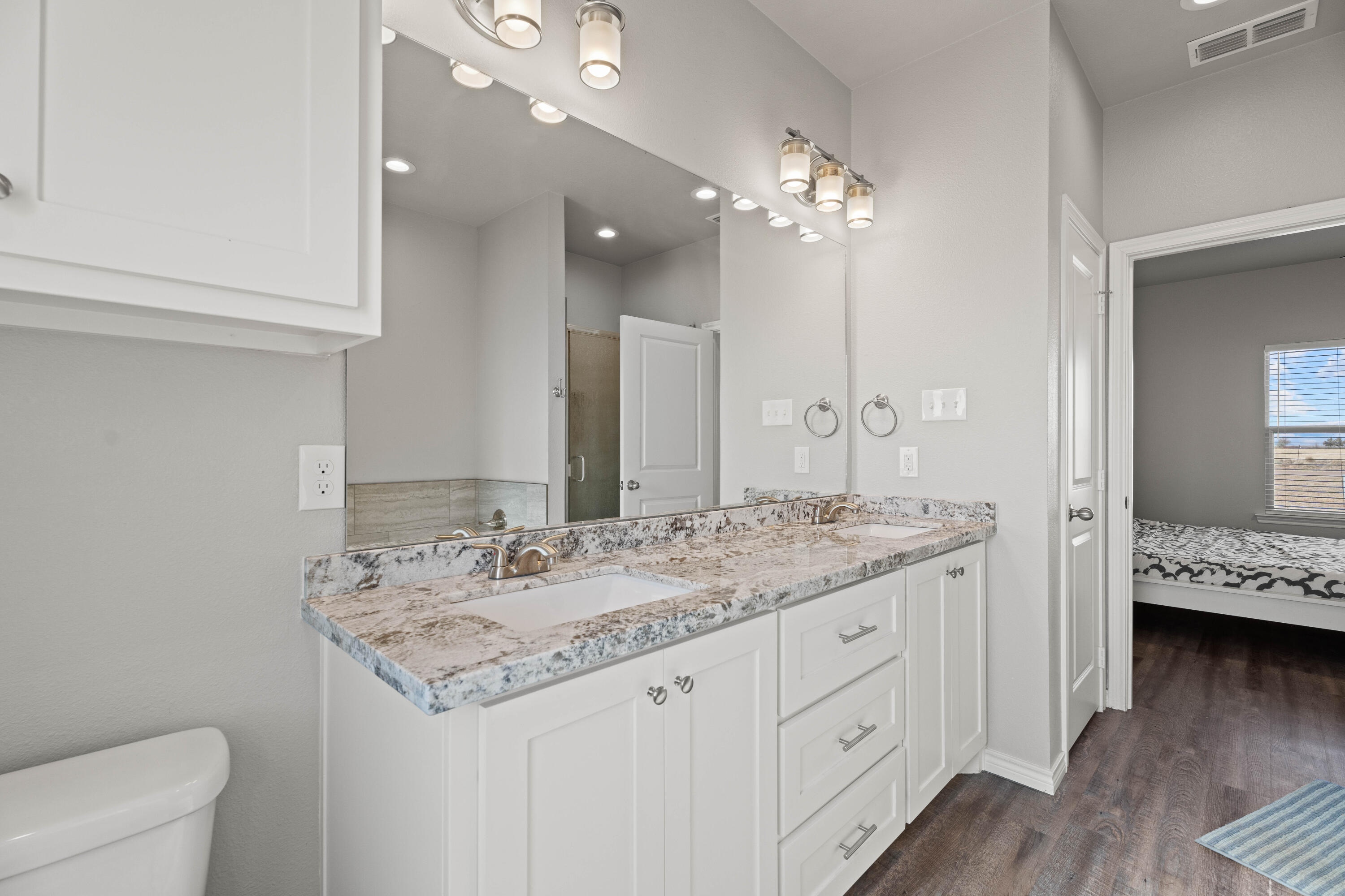 8907 County Road 6100 Shallowater, TX 79363 - Photo 15 of 24 a bathroom with a granite countertop double vanity sink and mirror