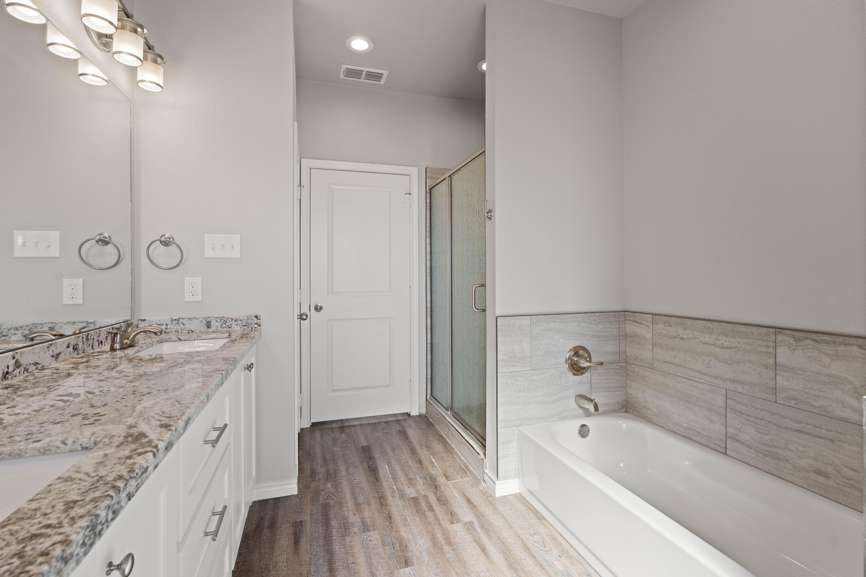 8907 County Road 6100 Shallowater, TX 79363 - Photo 16 of 24 a spacious bathroom with a granite countertop sink a mirror and shower